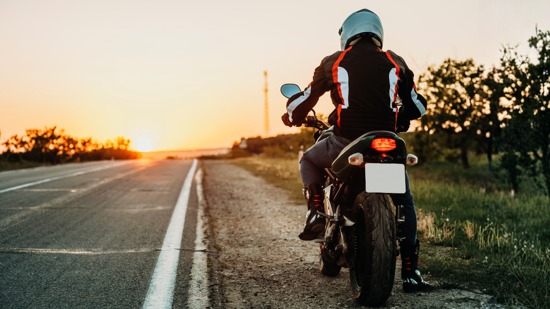 Motorcyclist on the side of empty road