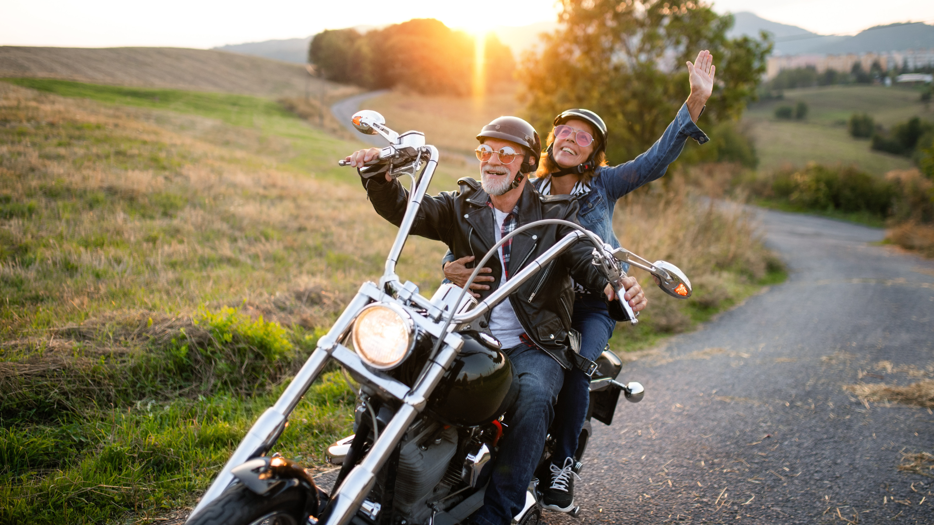 Mature couple riding happily down winding road