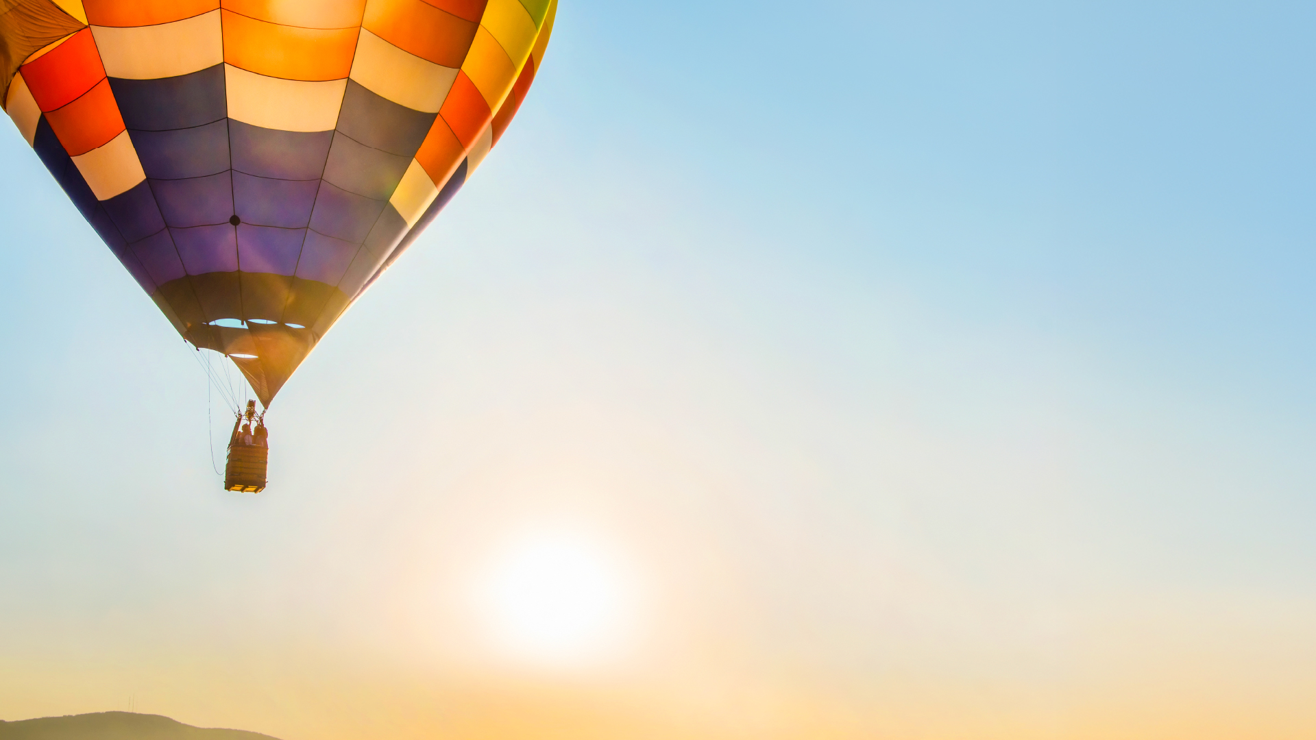 Hot air balloon ascending against a sunset