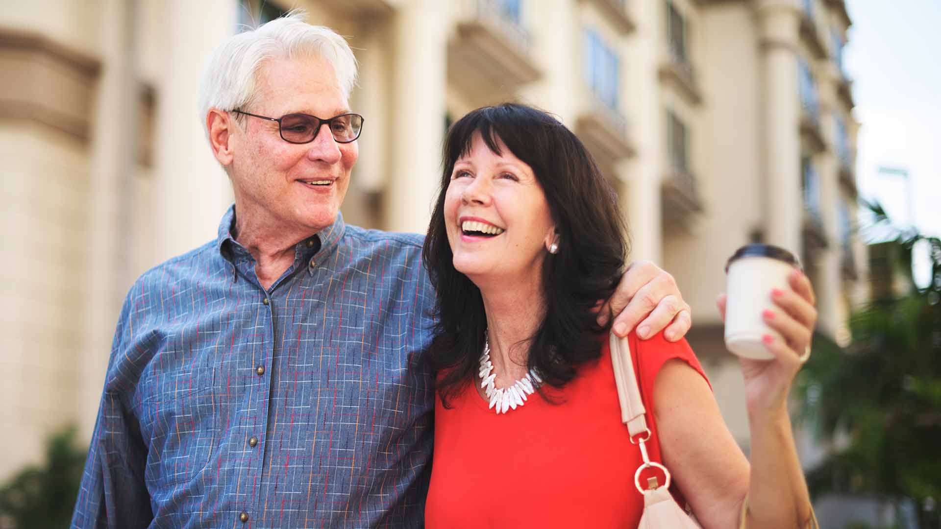 Mature couple smiling as they stroll down a street