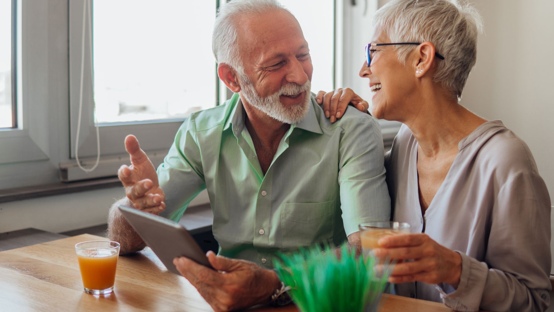 elder couple drinking beverages at a table