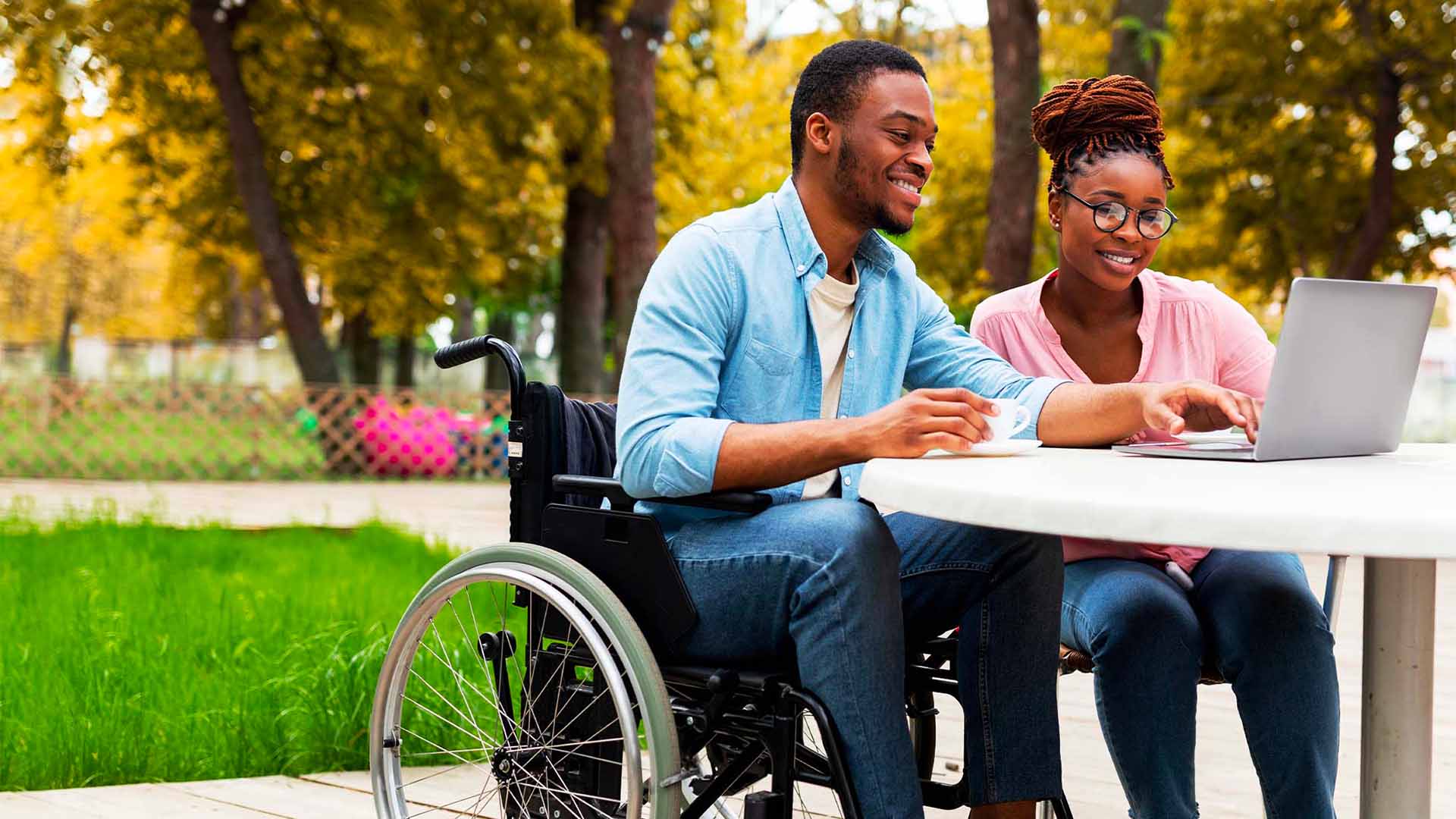 Couple outside looking at laptop