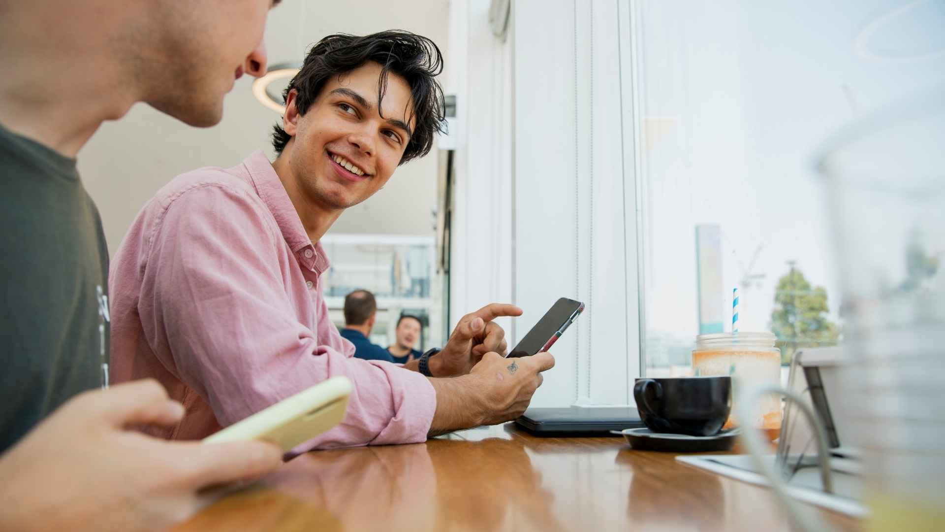 Two men at restaurant on cell phones