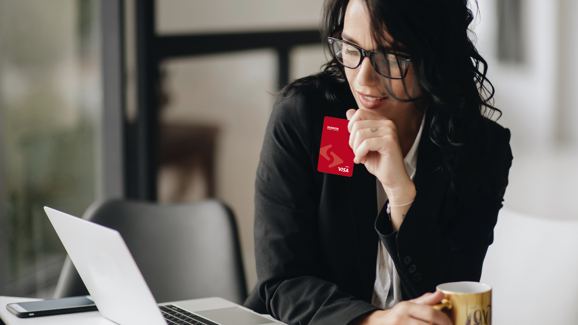 Woman holding a Soarion debit card.