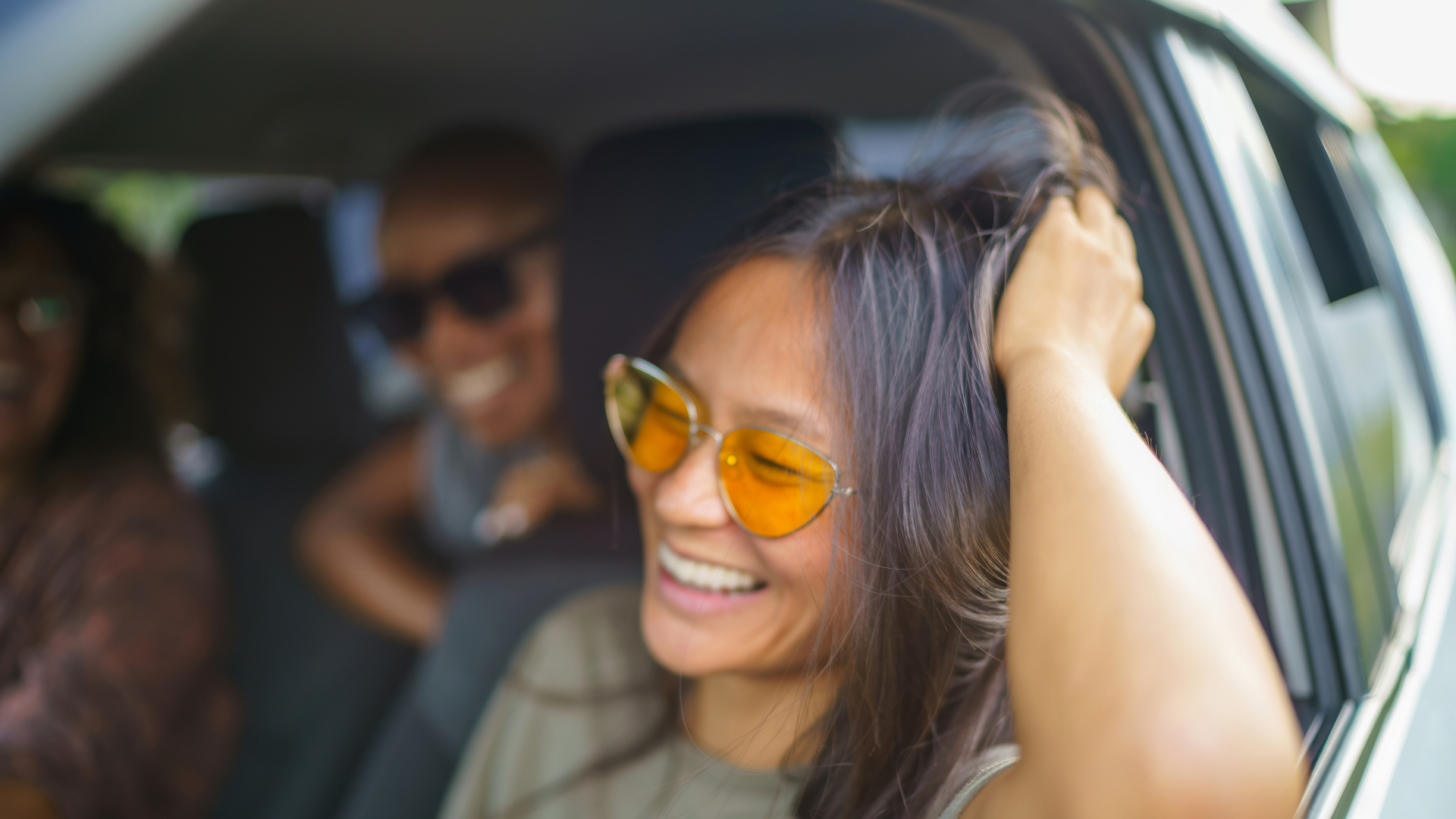 woman smiling and leaning out of open driver's side window