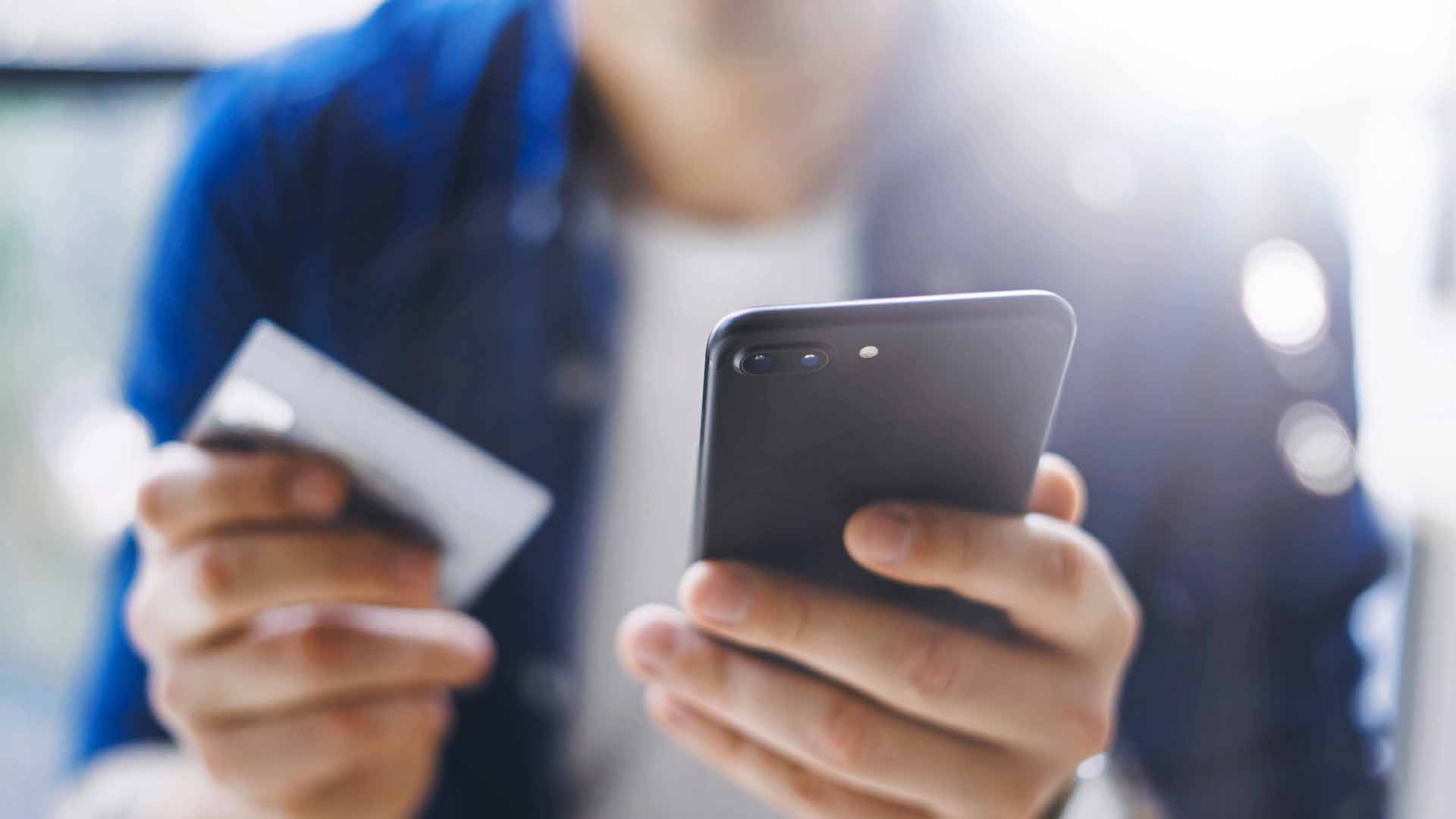Man with card and cell phone