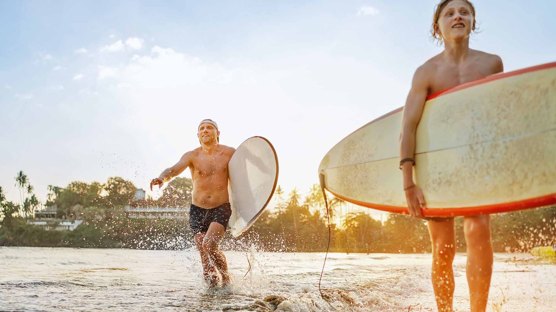 Father and son with a surfboards in beach