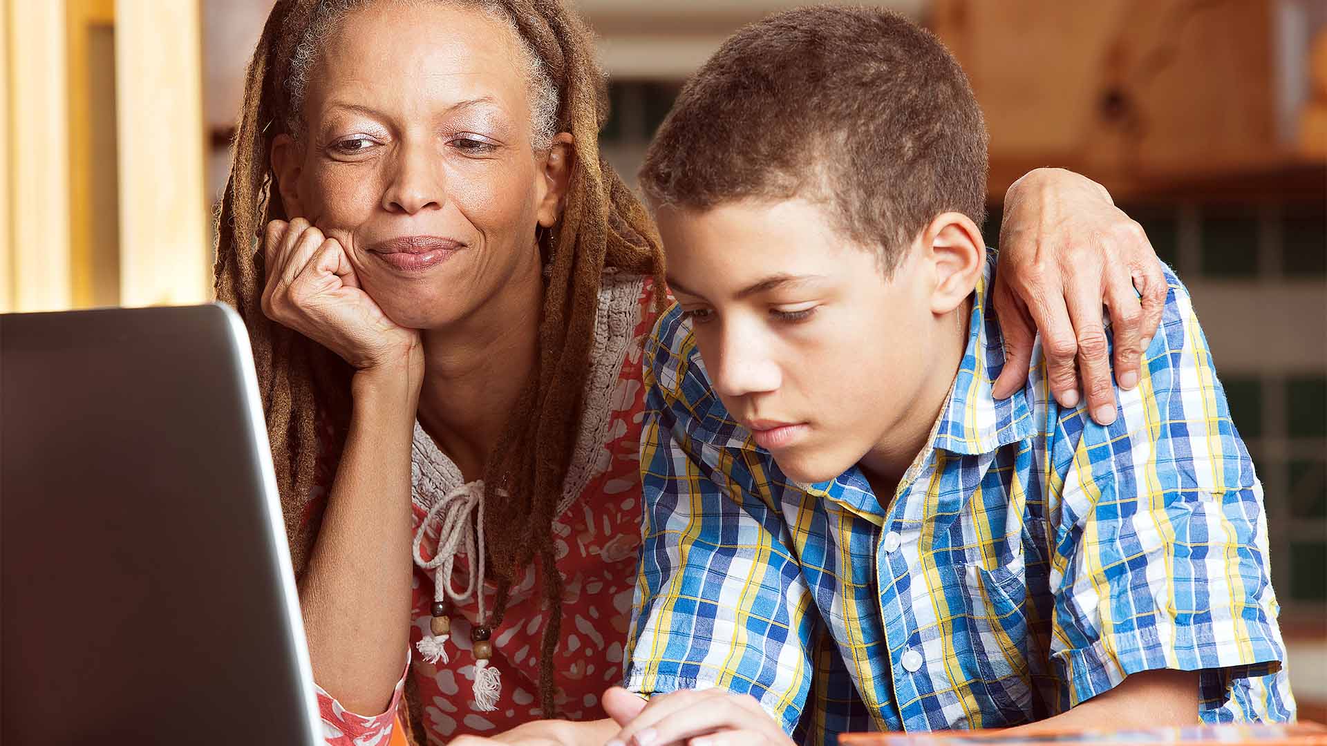 Mother and teen son looking at computer Mother and teen son looking at computer