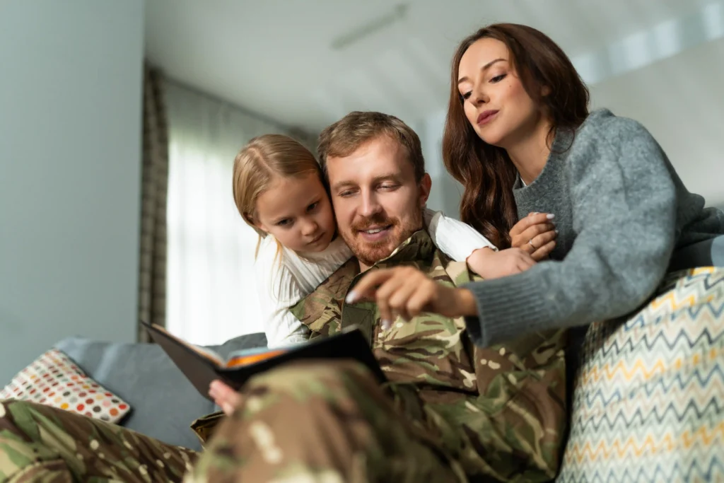 Service member in uniform reading with family on the couch